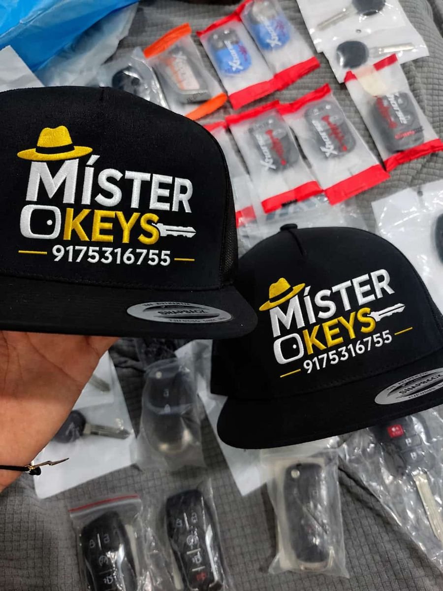 Míster Keys branded caps next to new car keys and remotes ready for programming